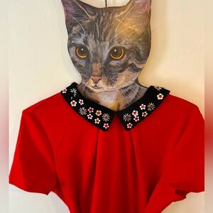 Red dress with black bedazzled collar and black patent leather belt